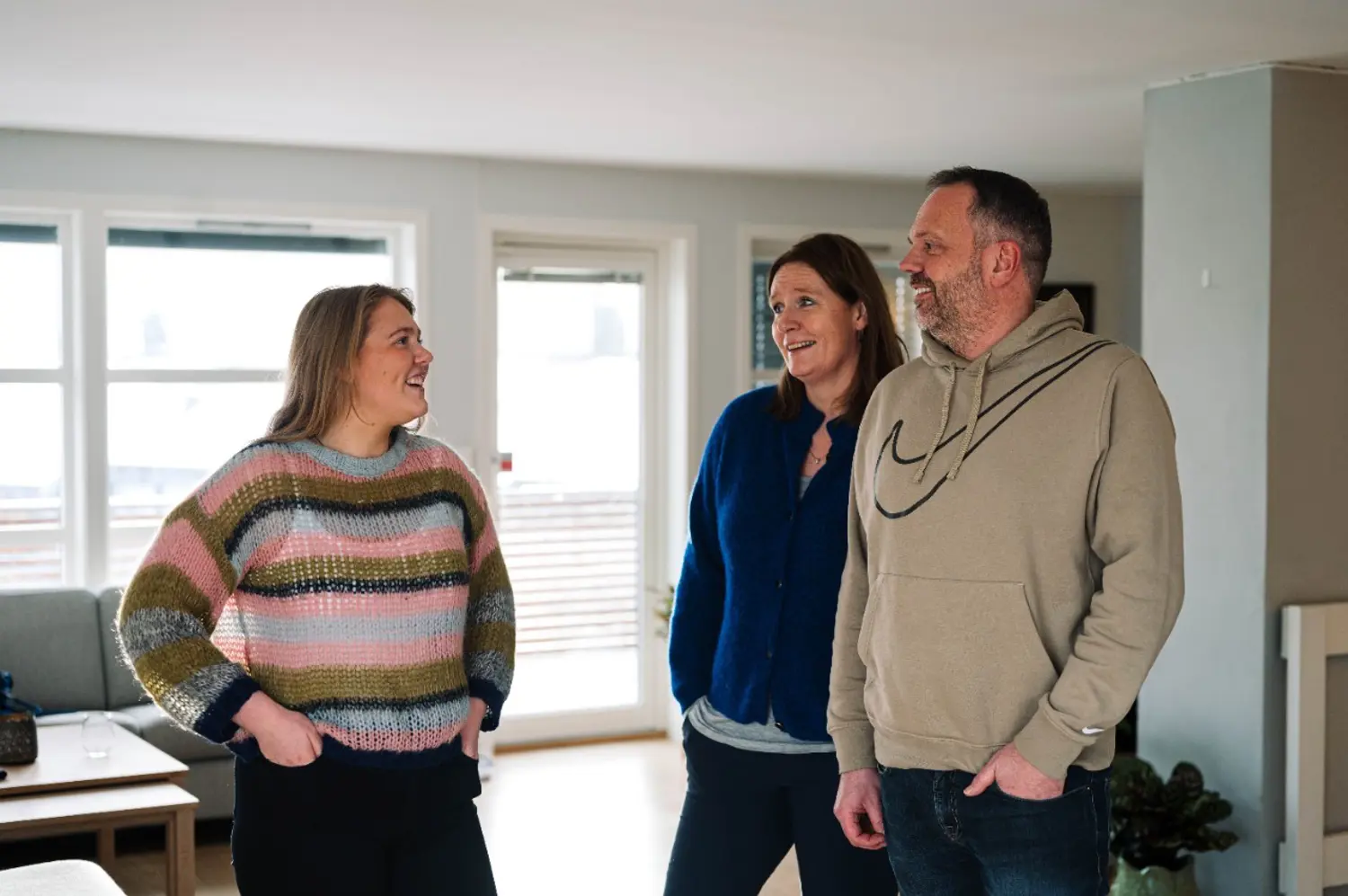 Foreldre Og Datter Stående I Stue